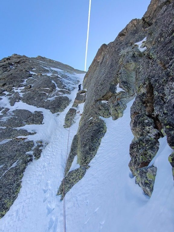 "Escalador ascendiendo una cascada de hielo en los Pirineos con cuerda