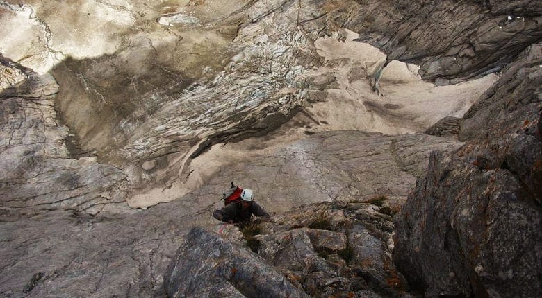 Un escalador escalando en la cra norte del Vignemale, con el glaciar de fondo.