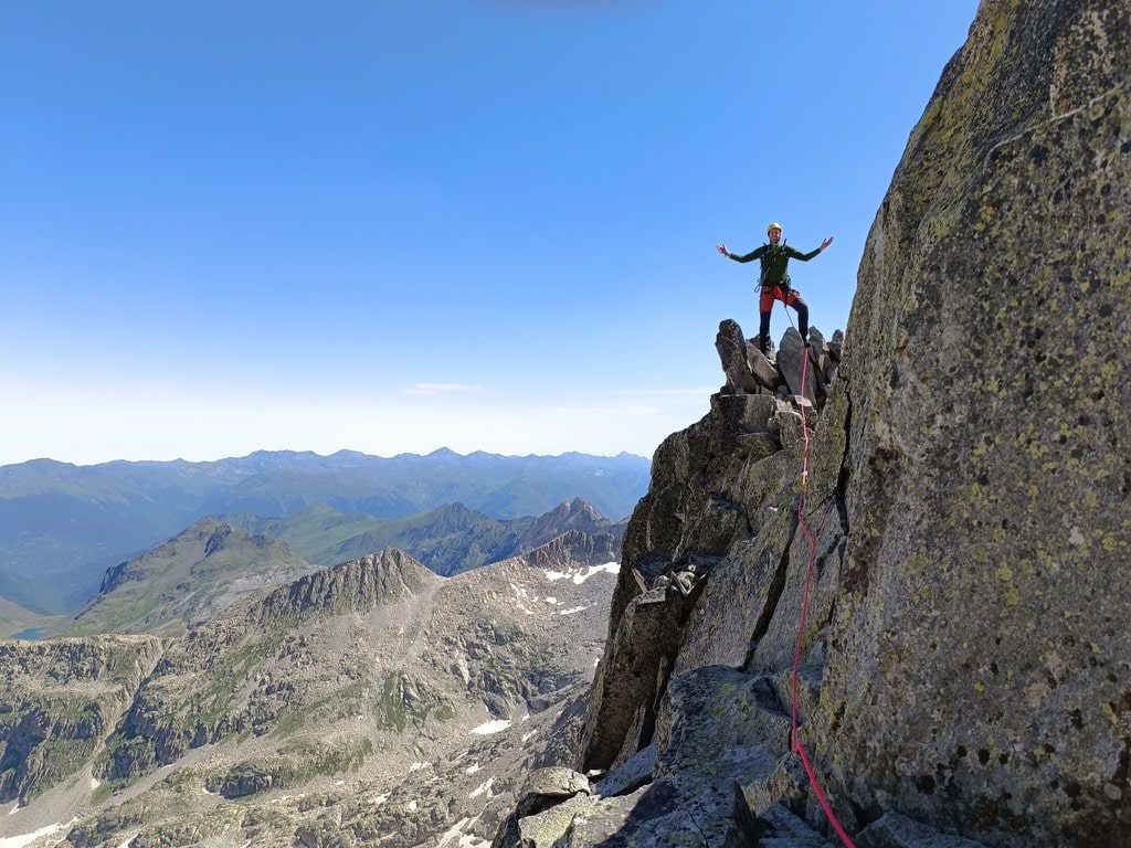 Un montañero subiendo en una cresta en el pirineo francés en una ascensión con guía de montaña.