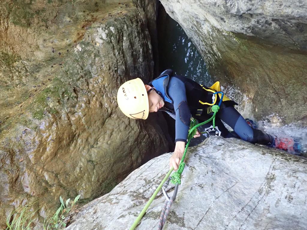 Niño haciendo un rapel en un barranco